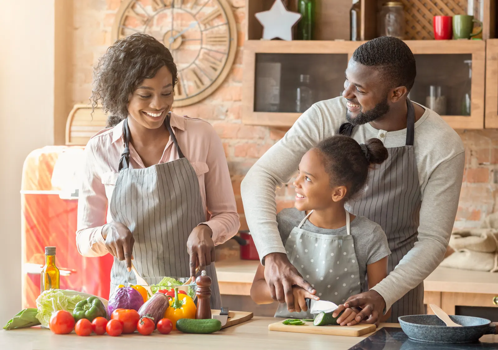 Two adults and a child cooking together at a kitchen worktop